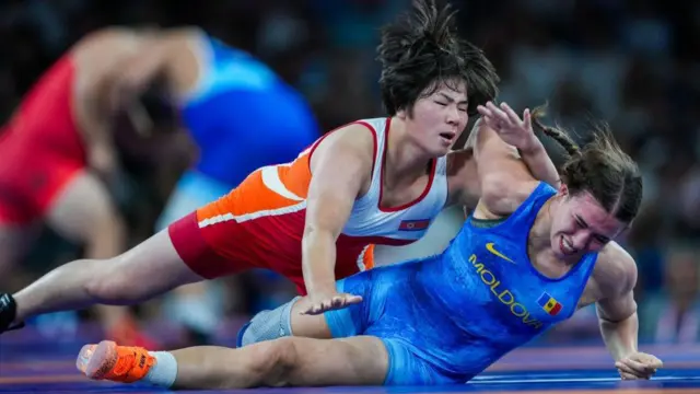 Gum Sol PAK (merah) dari Korea Utara melawan Irina Ringaci (biru) dari Moldova di cabang olahraga gulat putri 68 kg Olimpiade Paris 2024.