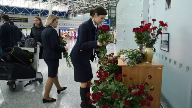 Các nhân viên sân bay Sochi đặt hoa tại điểm tưởng niệm các nạn nhân phi cơ quân sự Nga Tu-154