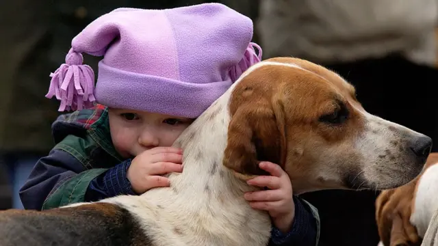 Criança abraçando cachorro