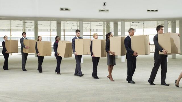 Trabalhadorescassino ganha no cadastrofila segurando cada um uma caixa num escritório vazio