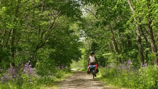 Sara Dykman bersepeda di kawsan hutan
