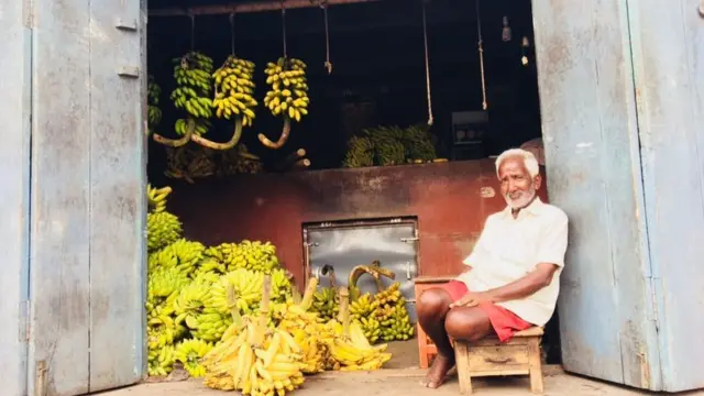 ਕੇਲਿਆਂ ਦੀ ਦੁਕਾਨ ਦੇ ਬਾਹਰ ਬੈਠਾ ਇੱਕ ਬਜ਼ੁਰਗ