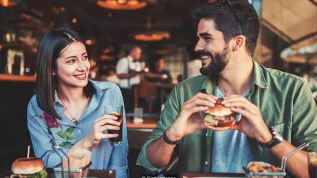 Pareja comiendo una hamburguesa.