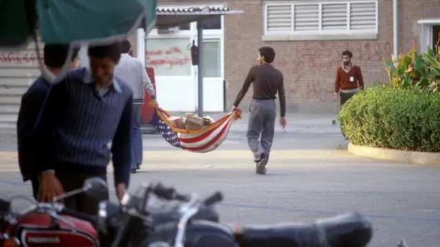 دانشجویان وابسته به جریان موسوم به "پیرو خط امام" در روز ۱۵ نوامبر ۱۹۷۹ با پرچم ایالات متحده آمریکا زباله جا به جا می‌کنند.