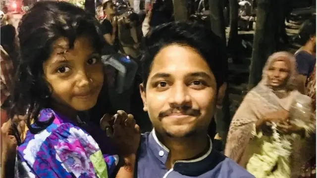 শিশু জিনিয়াকে উদ্ধারের পর আরাফাত চৌধুরীর কোলে।
