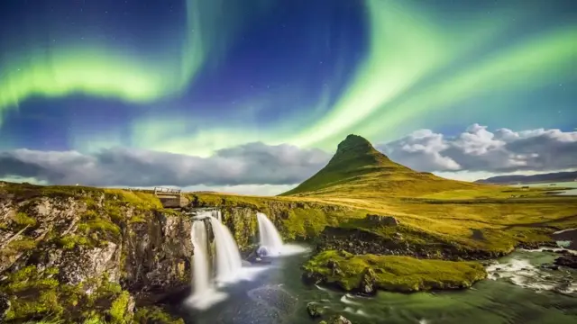 aurora sobre Kirkjufell y las cascadas aledañas en Islandia de noche.