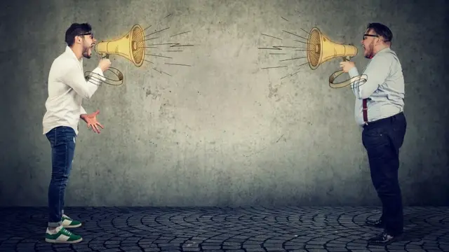 Businessmen screaming into a megaphone at each other