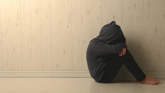 Niño que se esconde por abuso sexual.