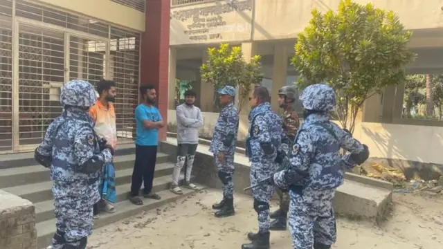 একটি ভোট কেন্দ্রে নিরাপত্তা বাহিনীর কয়েকজন সদস্য বেসামরিক তিজনের সঙ্গে কথা বলছেন