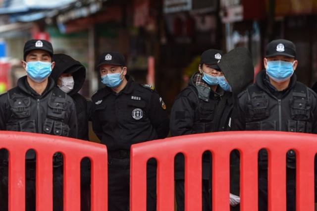 Policías vigilan el mercado de marisco de Huanan, en Wuhan, China.