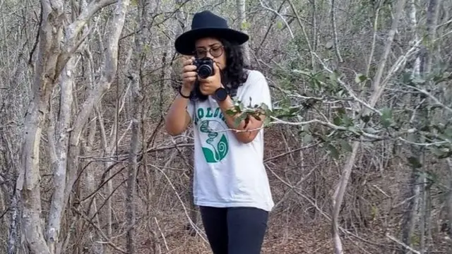 Sabrina Oliveira segura câmera fotográfica