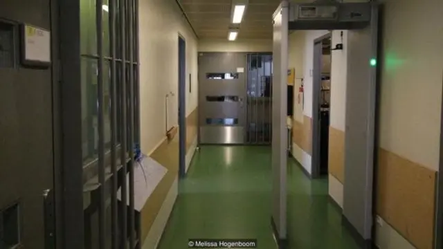 Staf dan pengunjung melewati pendeteksi logam saat memasuki dan keluar dari penjara.