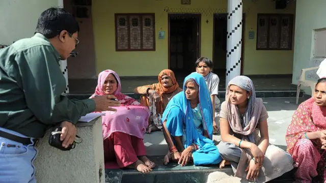 ગ્રામજનો સાથે વાત કરતા સ્વાસ્થ્ય અધિકારી