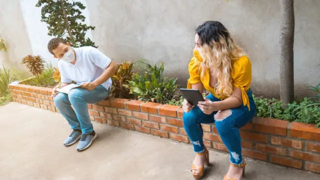 Dos personas con mascarilla guardando la distancia social.