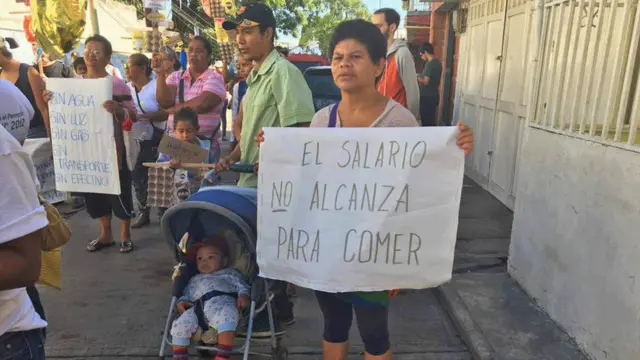Mujer con letrero de "El salario no alcanza para comer"
