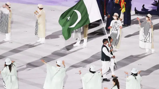 پاکستان کی طرح سے ملک کا جھنڈا اٹھانے والی ماحور شہزاد اور محمد خلیل اختر۔ ماحور نے ماسک نہیں پہنا ہوا تھا جس کے بارے میں کئی جگہوں پر بات بھی کی گئی