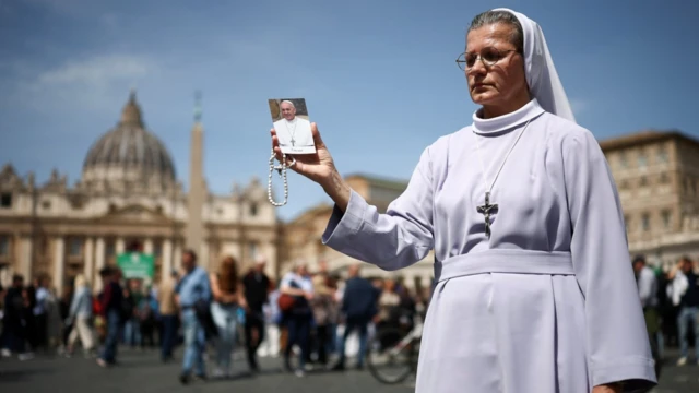 Papa Francesco'nun ölümünün Vatikan tarafından duyurulmasının ardından, 21 Nisan 2025'te Papa Francesco'nun bir resmini elinde tutan rahibe.