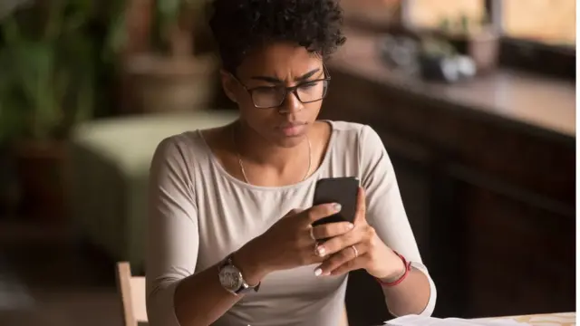 Jovem olha com olhar preocupado algobonus apostaseu celular