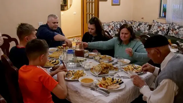 The Hoxha family sits at the table during the iftar, the meal after sunset, during the Islamic fasting month of Ramadan in Tirana on April 24, 2020. - Stuck home under a coronavirus lockdown, 81-year-old Osman Hoxha and his family quietly mark the start of Ramadan inside their Tirana apartment, recalling the dark days of communism when practicing religion meant risking death. Like many parts of the world, mosques in Muslim-majority Albania are eerily empty while iftar supper tables have fewer chairs than normal as families shelter at home under restrictions imposed to curb the spread of the virus. (Photo by Gent SHKULLAKU / AFP) (Photo by GENT SHKULLAKU/AFP via Getty Images)