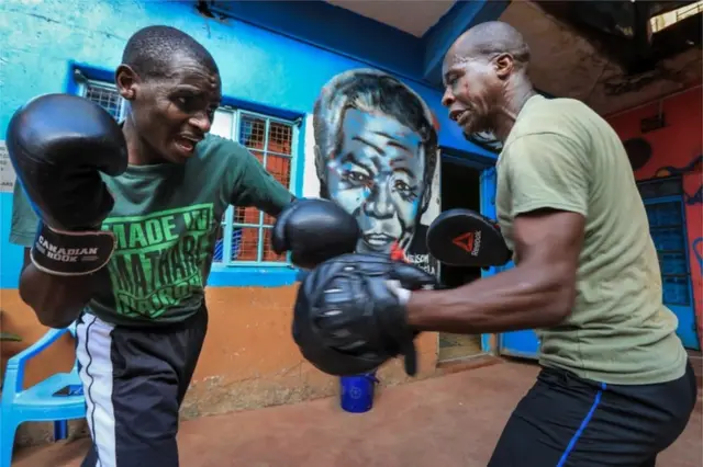 Two men practise boxing.