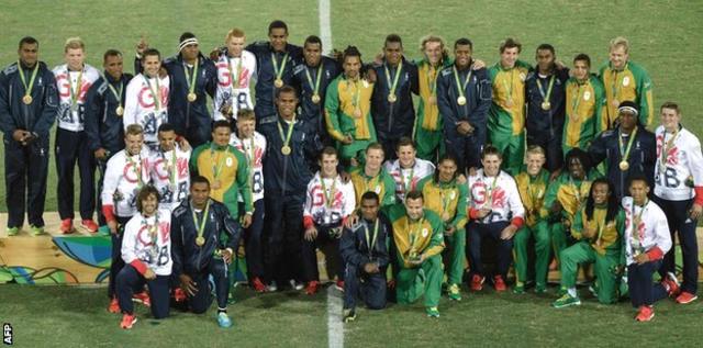 メダルを獲得したフィジー、英国、南アフリカの選手たちが入り交じり写真撮影のためにポーズした