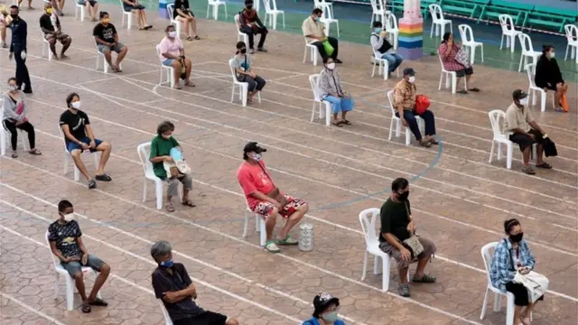 ชาวดอนเมืองต่อแถวรับอาหารจากกองทัพอากาศภายใน รร.วัดดอนเมือง กทม. โดยมีการจัดระเบียบให้เว้นระยะห่างทางสังคม เมื่อ 22 เม.ย.