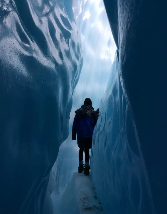 Una chica caminando por un glaciar