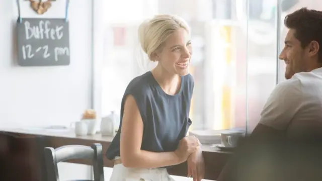 Una pareja charlando y ríendo en un café
