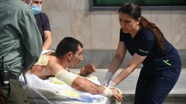 A handout photo released by the Armenian Foreign Ministry shows specialists delivering medical support to a man, who is said to be a civilian injured during clashes in the breakaway region of Nagorno-Karabakh, September 27, 2020.