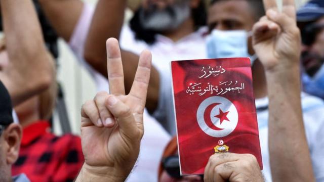 أحد المتظاهرين يرفع نسخة من الدستوري التونسي (صورة أرشيفية)