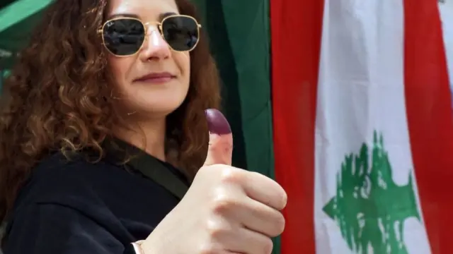 A Lebanese woman displays her ink-stained finger after voting at the Lebanese embassy in Riyadh during parliamentary elections on May 6, 2022