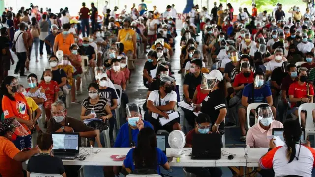 Des citoyens s'inscrivent pour se faire vacciner avec le vaccin Pfizer COVID-19 dans un complexe sportif à Caloocan City, Metro Manila, Philippines, le 16 juin 2021