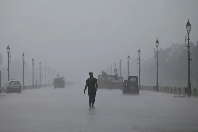 رجل يسير في طريق "راجباث" وهو الموقع الذي يشهد استعراض يوم الجمهورية السنوي، خلال موجة من الرياح الموسمية في نيودلهي بالهند.