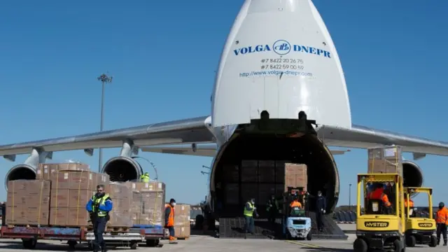 Avião estacionado ao ladozebet telegram channelcaixas empilhadas e agente do aeroporto francês