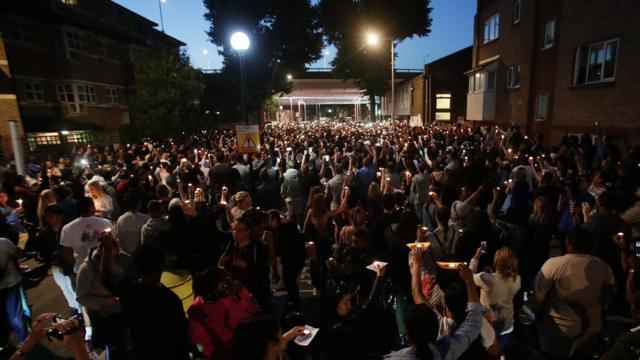 People hold candles outside Latymer Church, close to Grenfell Tower