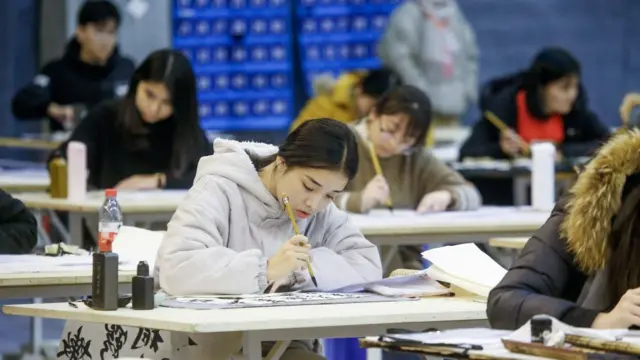 Mujer china escribiendo sobre un cuaderno