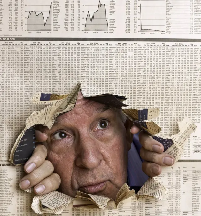 Hombre mirando por roto en diario