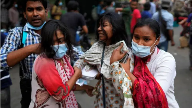 মোদীর সফর বাতিলের দাবিতে বিক্ষোভে প্রতিপক্ষের হামলায় আহত এক বিক্ষোভকারীকে সহায়তা করছেন তারই দুই বন্ধু যারা নিজেরাও বিক্ষোভ করছেন।