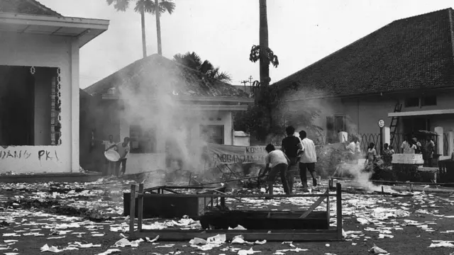 Beberapa orang merusak dan membakar kantor CGMI, onderbouw PKI, di Jakarta, 13 Oktober 1965.