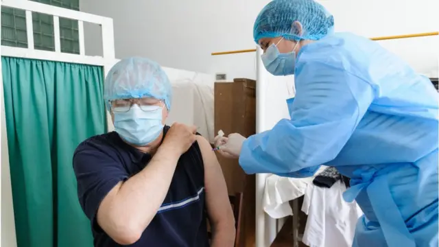 কোভিশিল্ড টিকা নিচ্ছেন একজন স্বাস্থ্যকর্মী