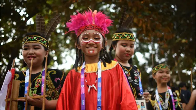 Children smile after having makeup applied before their performance
