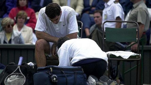 Pete Sampras receiving treatment on his injured shin in his Wimbledon second-round match in 2000