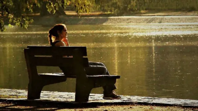 Mujer sentada en un banco.