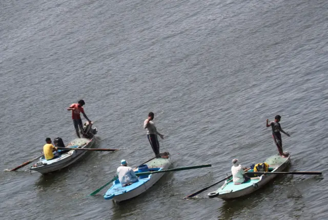 Men fish from boats on the River Nile in Cairo, Egypt