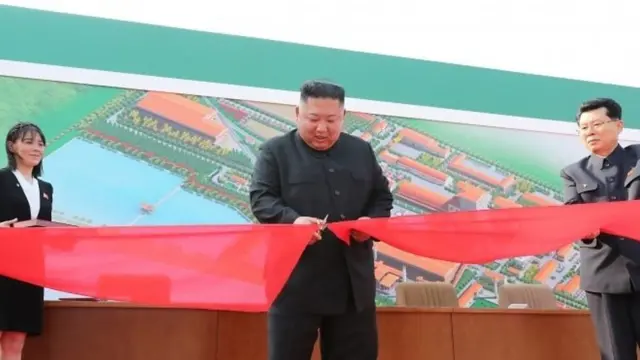Kim Jong-un cutting ribbon at factory opening