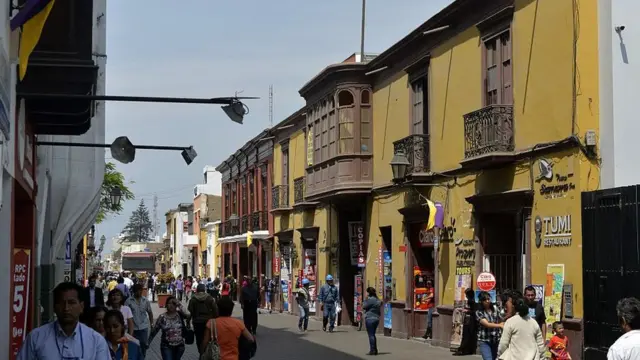 Casona con balcoens de madera que aparenta un pasado señorial pero que está convertida en un centro comercial.