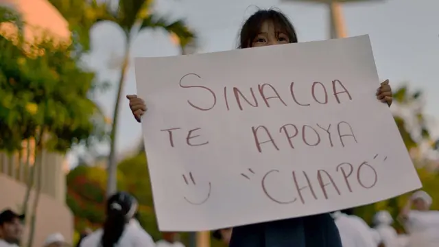 Una niña sostiene una pancarta que dice: "Sinaloa te apoya Chapo :)"