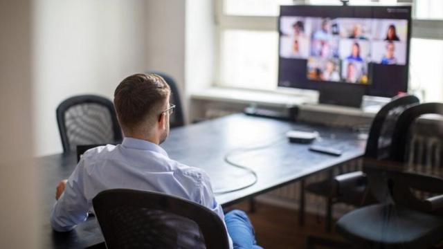 Homem sentadobloga betfrente a TV participandobloga betreunião remota