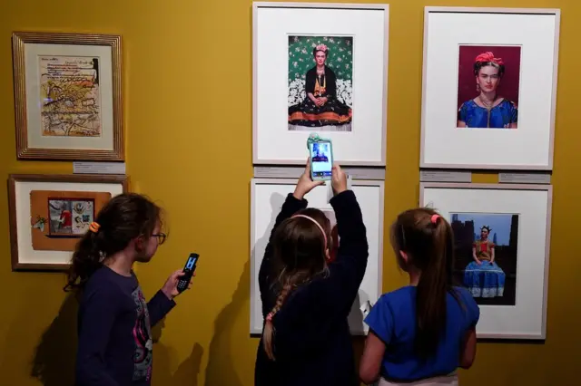 Visitantes sacan fotos de las piezas de la exposición