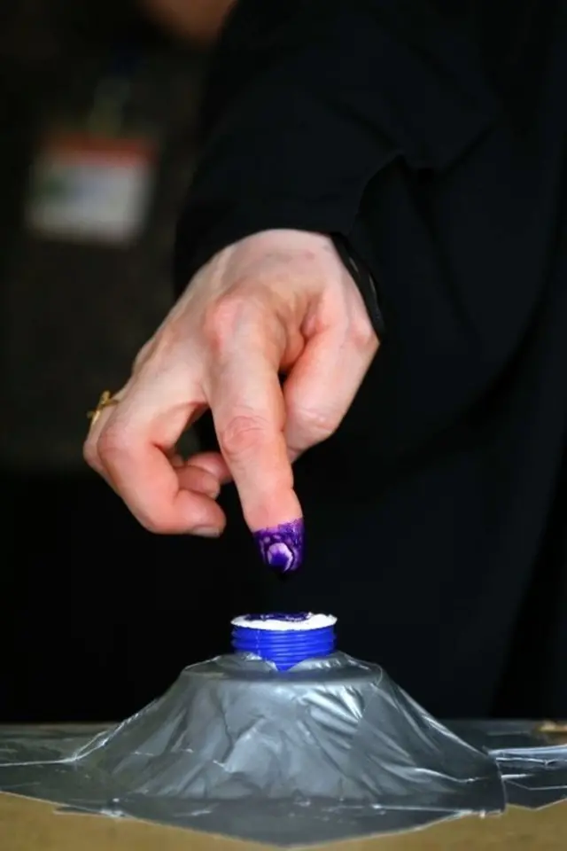 یک زن عراقی در حال زدن انگشت در جوهر رای گیری